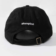 Black cap with 'akomplice' logo on a white background