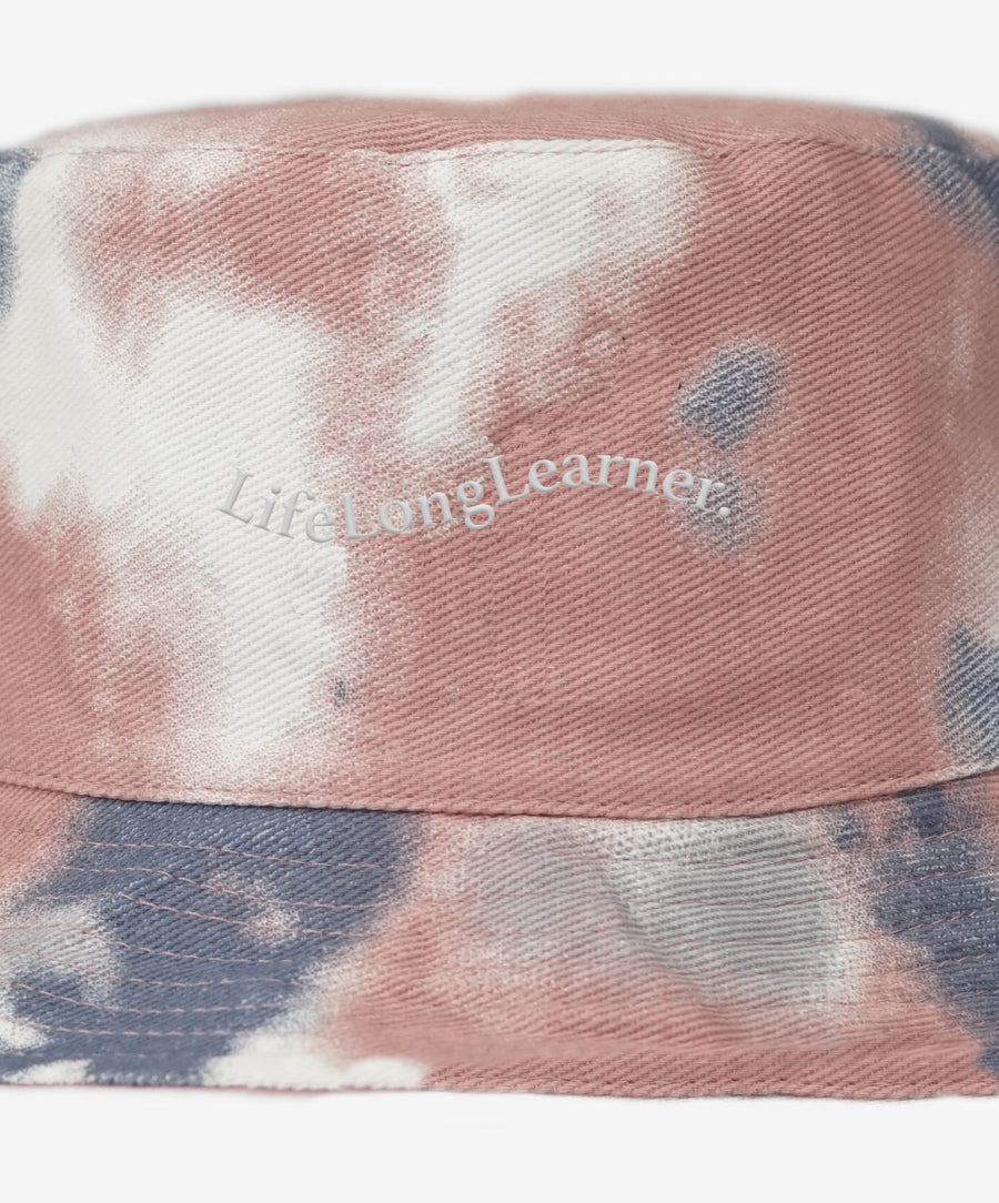 Tie-dye bucket hat with 'Lifelong Learner' text on a white background