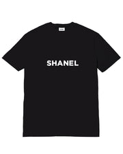 Black t-shirt with 'SHANEL' printed on it against a white background
