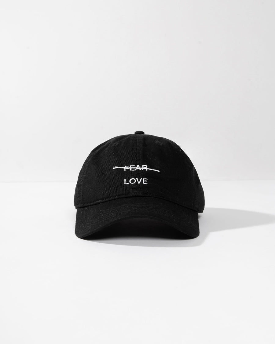 Black cap with 'FEAR LOVE' text on a white background