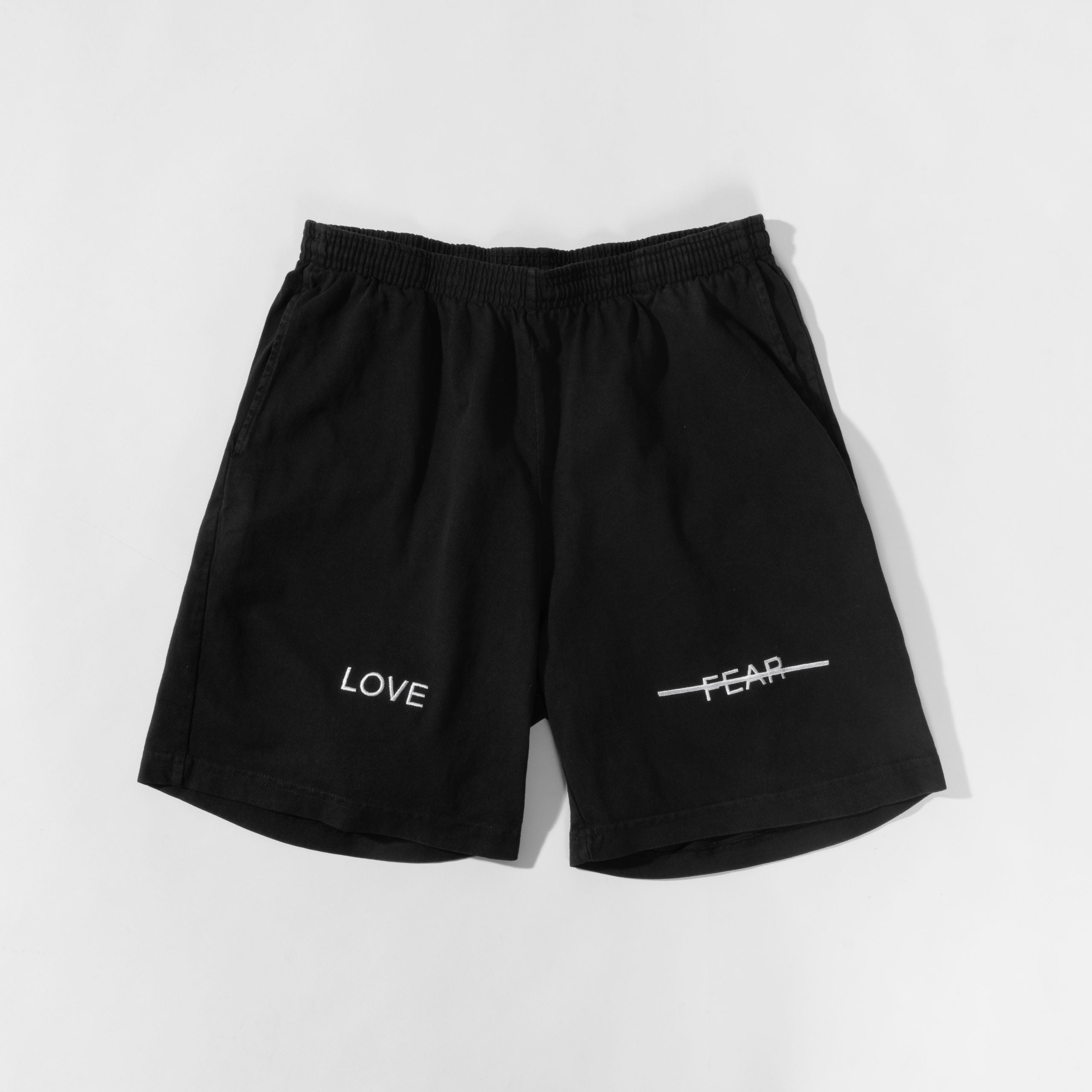 Black shorts with 'LOVE' and 'FEAR' text on a white background