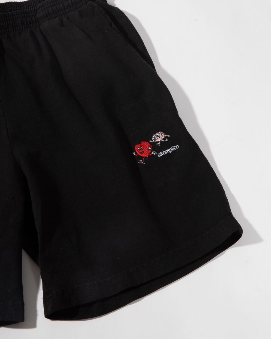 Black shorts with a small embroidered logo on a white background