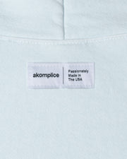 Light blue fabric with a label reading 'akomplice Passionately Made in The USA'.