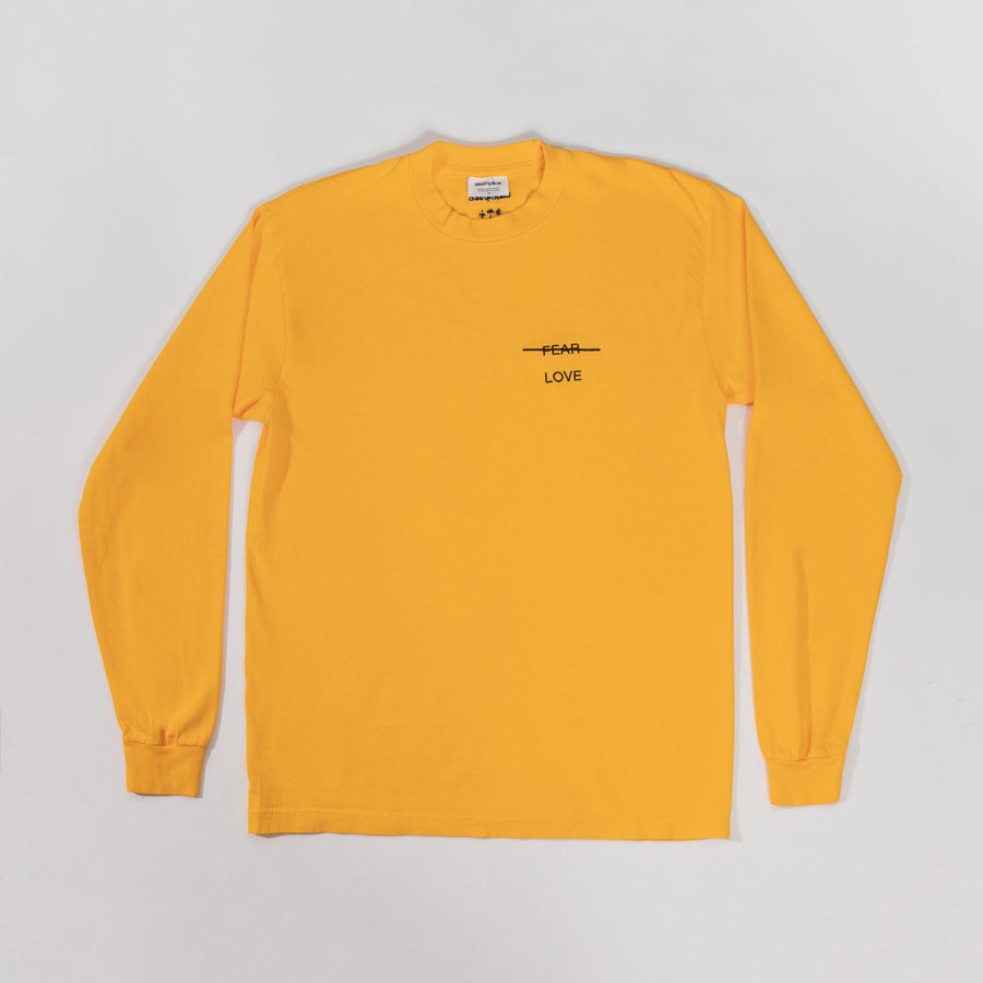 Yellow long-sleeve shirt with a black graphic and text on a gray background