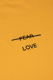 Yellow sweatshirt with 'FEAR LOVE' text on a mustard yellow background