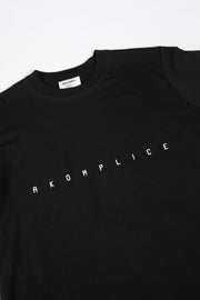 Black t-shirt with 'AKOMPLICE' text on a white background
