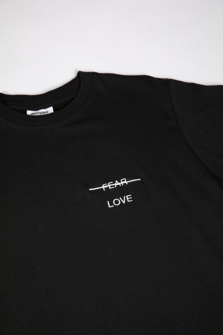 Black t-shirt with 'FEAR LOVE' text on a white background