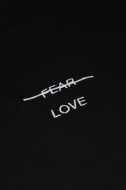 Text 'FEAR LOVE' embroidered on a black background