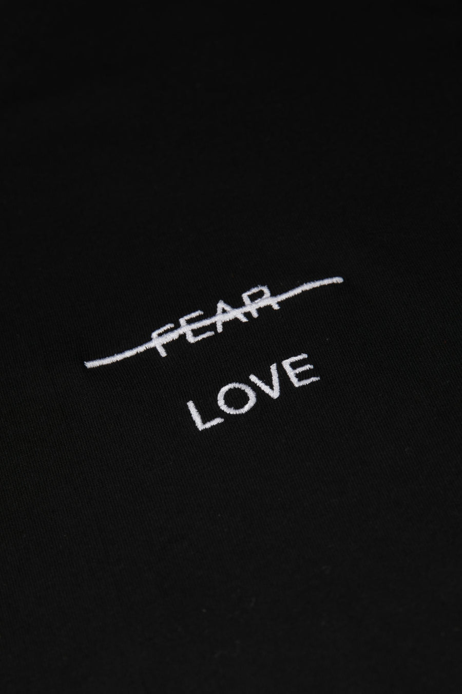 Text 'FEAR LOVE' embroidered on a black background