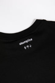 Black t-shirt with white 'akomplice' logo on a white background