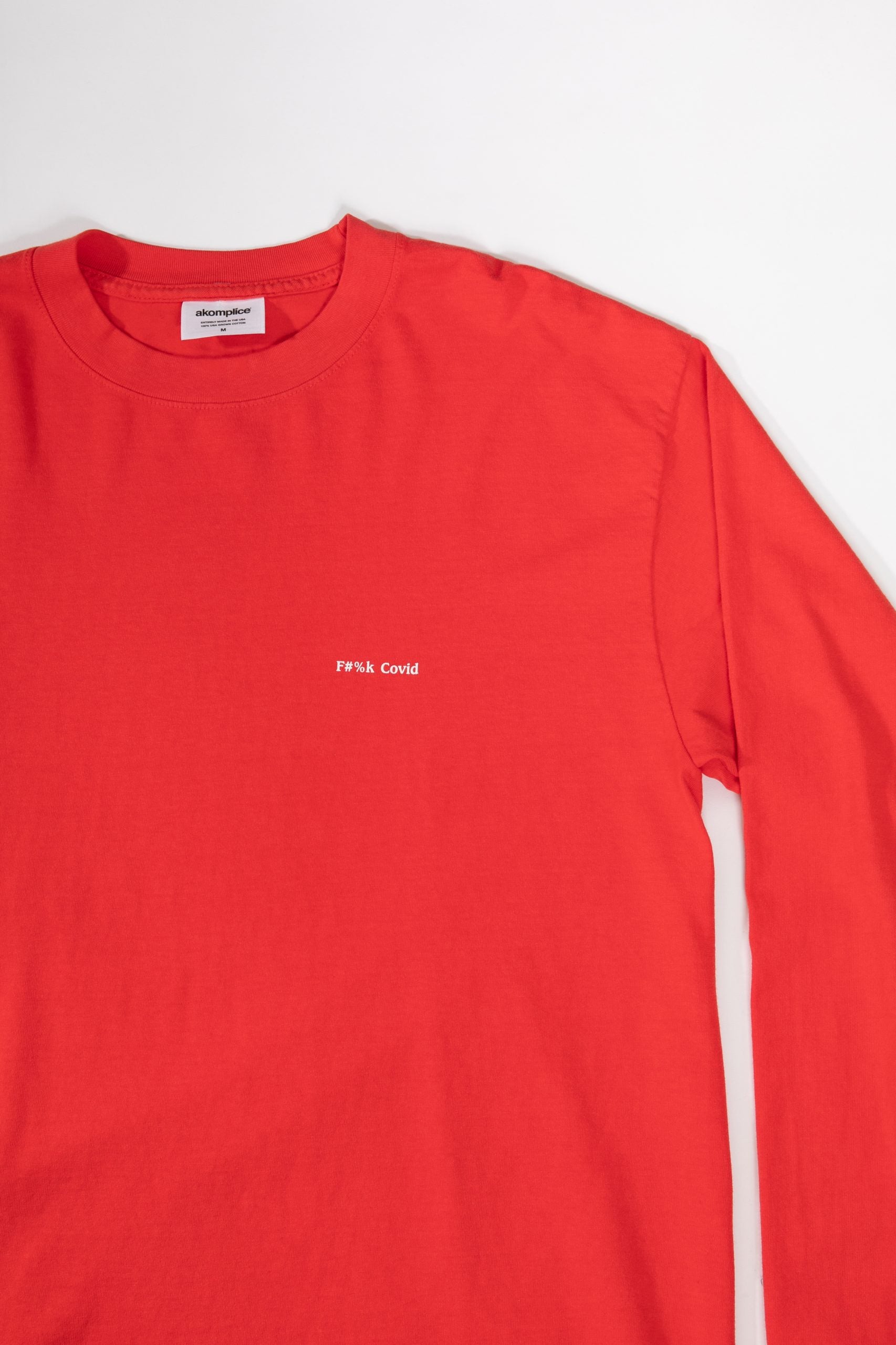 Red long-sleeve shirt with a small white logo on a white background