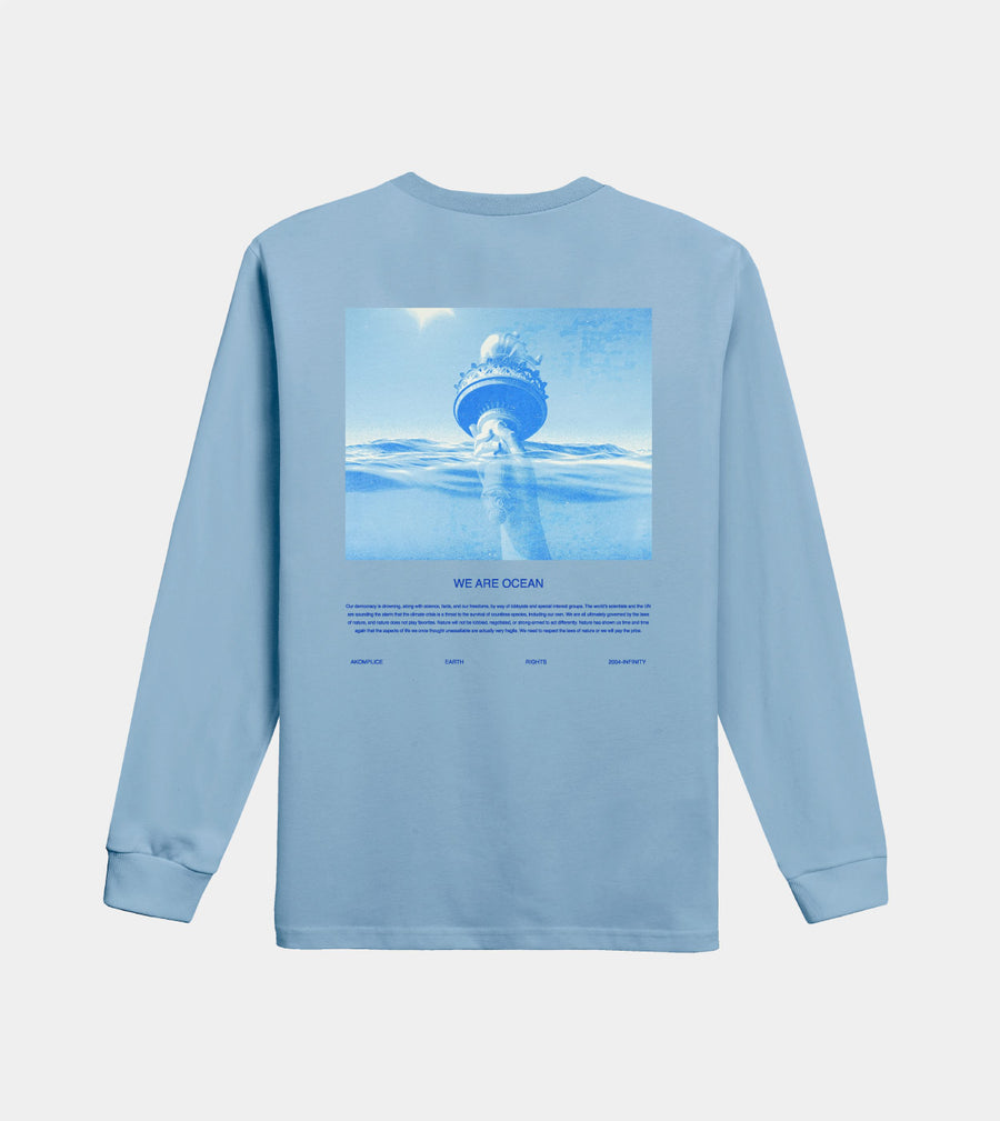 Light blue long-sleeve shirt with ocean-themed graphic and 'We Are Ocean' text on a light gray background