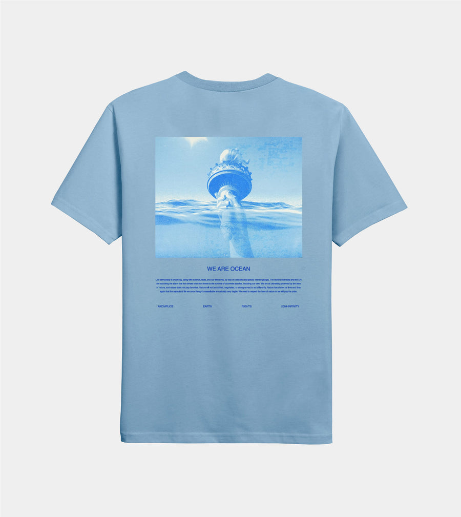 Light blue t-shirt with an underwater graphic and 'We Are Ocean' text on a light gray background
