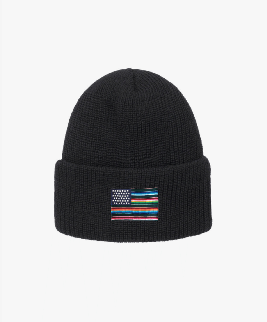 Black beanie with a colorful striped flag patch on a white background
