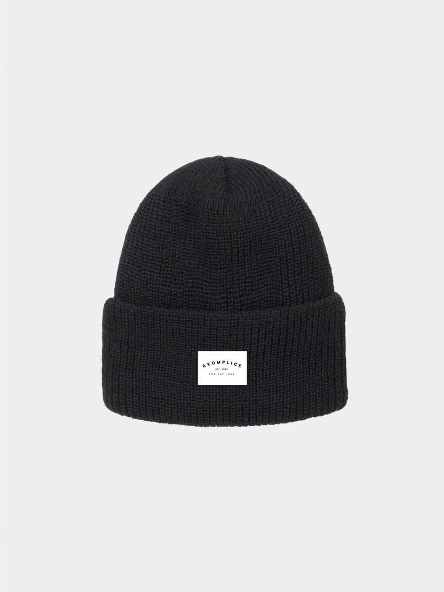 Black beanie with a white label on a light gray background