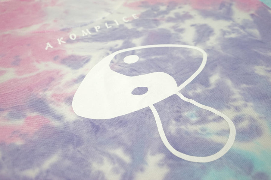 Logo with a stylized face on a tie-dye background with 'AKOMPLICE' text.