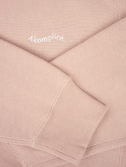 Close-up of pink fabric with 'Akomplice' branding.