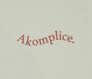 Text 'Akomplice' in red on a beige background