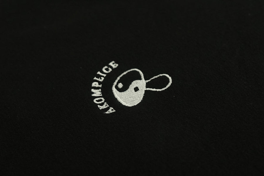 White embroidered logo on a black background