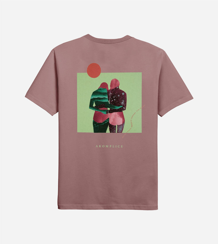 Mauve t-shirt with a graphic of two people hugging on a green background, featuring the brand 'akomplice'.