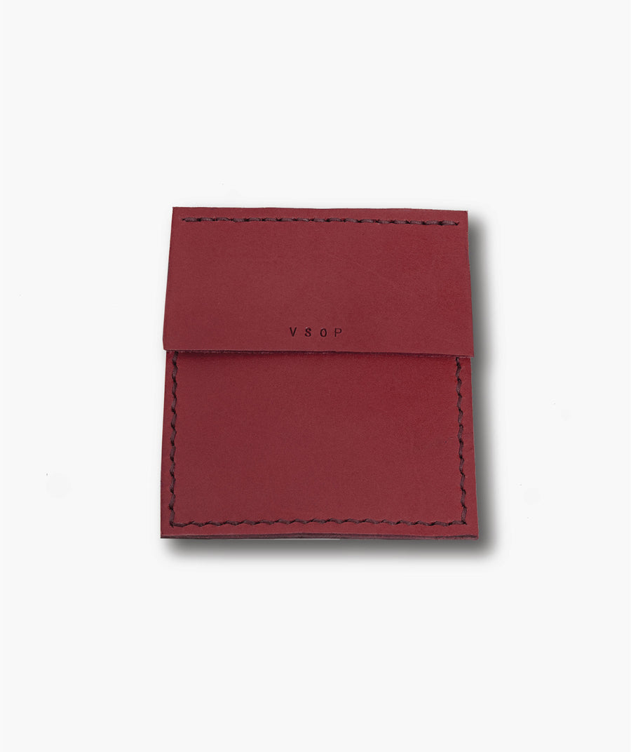 Red leather cardholder with 'VRAI' branding on a white background
