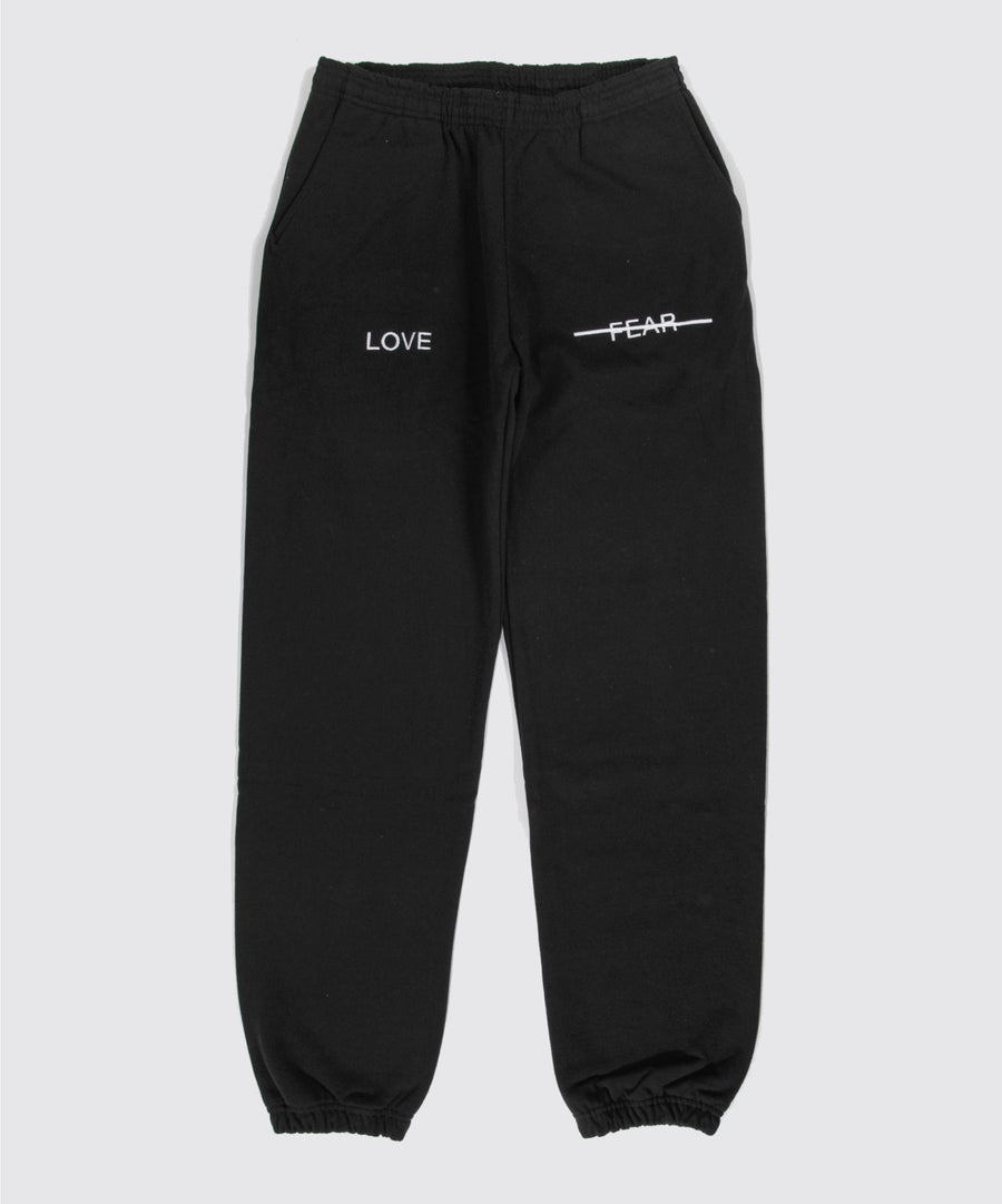 Black sweatpants with 'LOVE' and 'FEAR' text on a white background