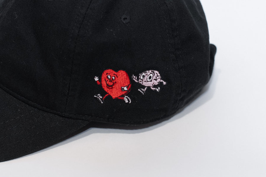 Black cap with embroidered designs on a white background