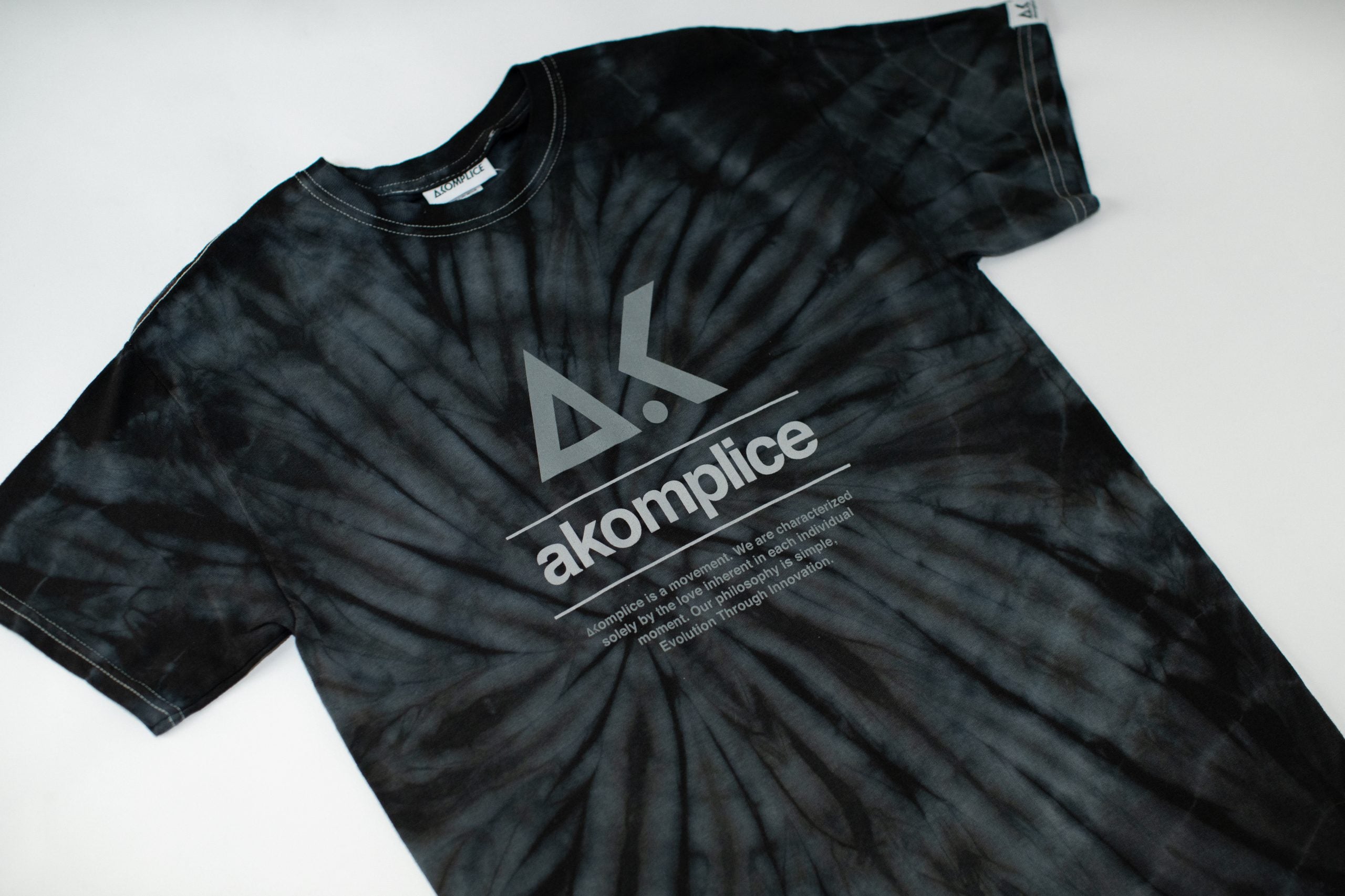 Black tie-dye t-shirt with a logo and text on a white background