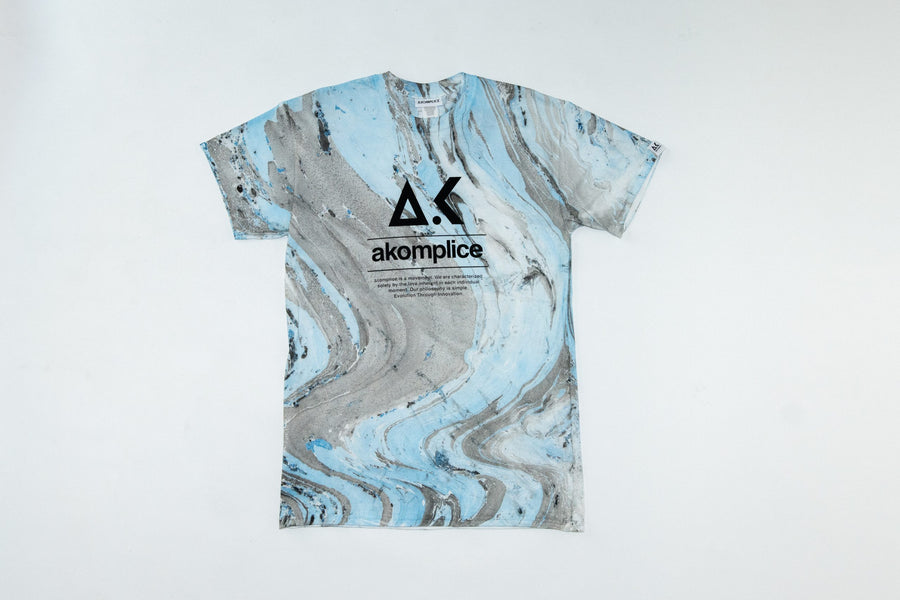 T-shirt with a marbled design and 'akomplice' logo on a white background