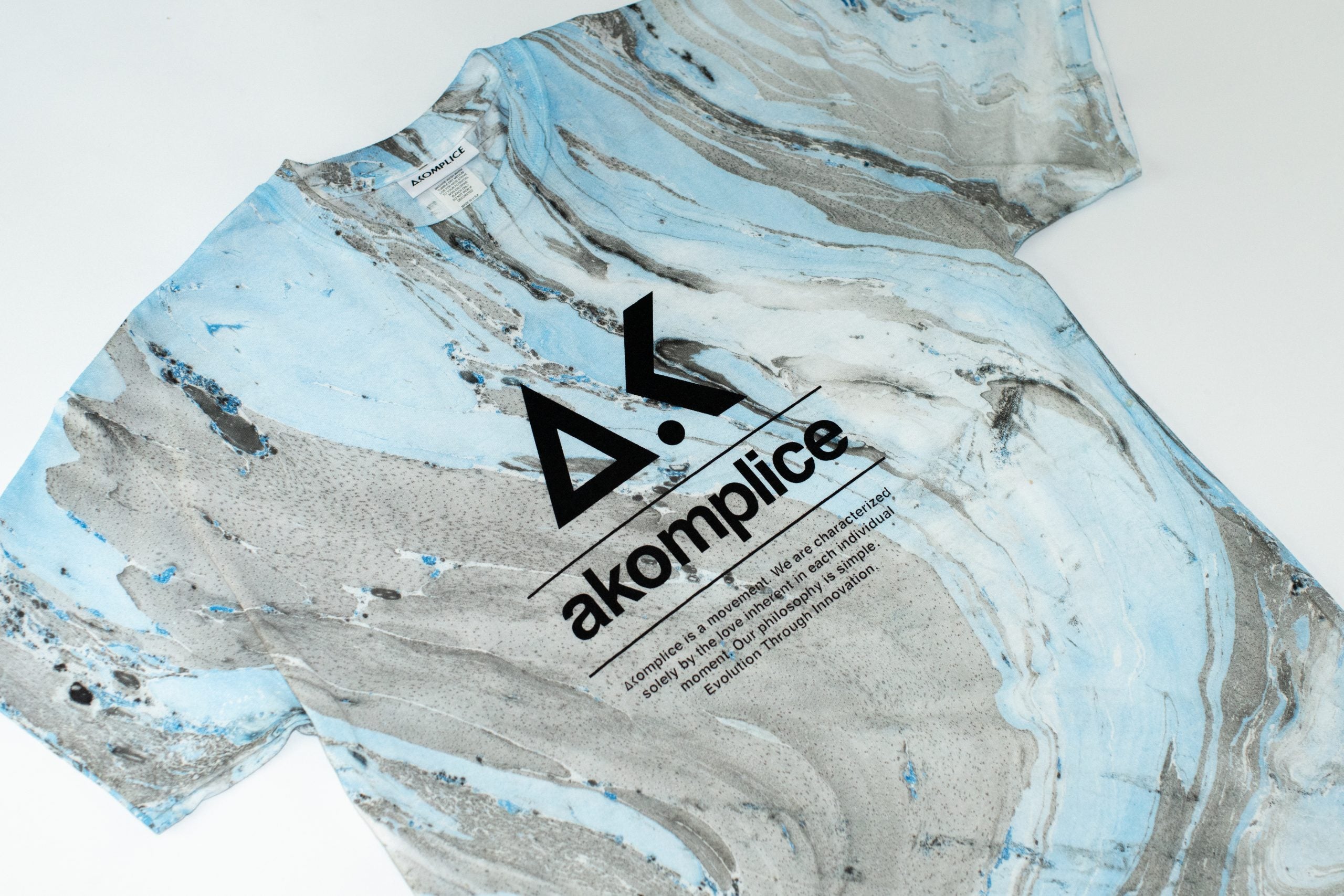 Marbled paper with 'akomplice' logo and text on a white background