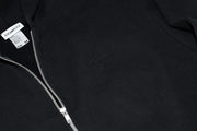 Close-up of a black hoodie with a zipper and brand label.