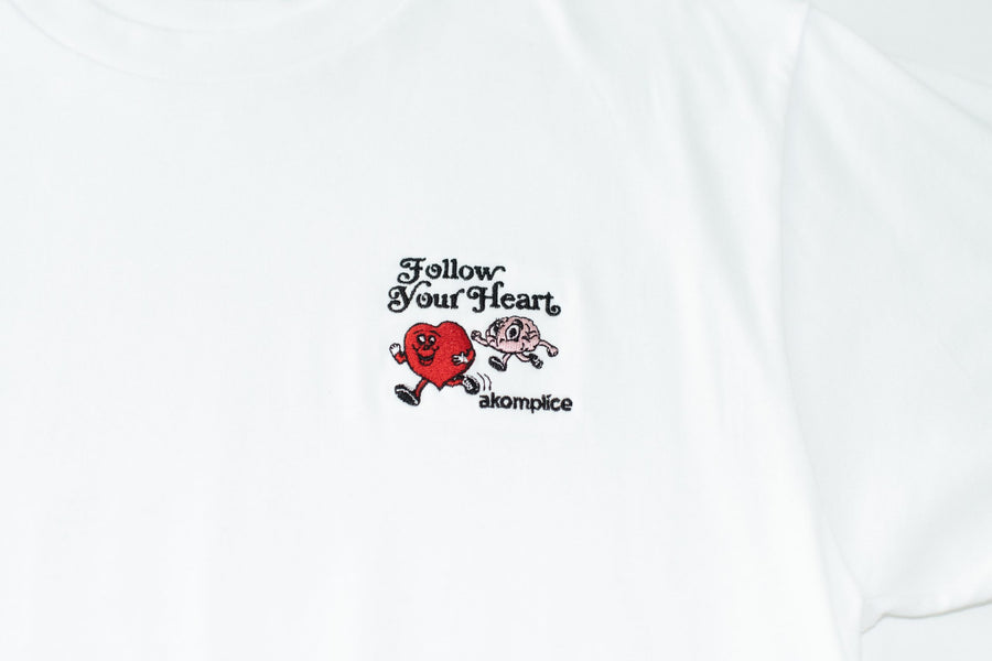 White t-shirt with a red heart graphic and text on a white background