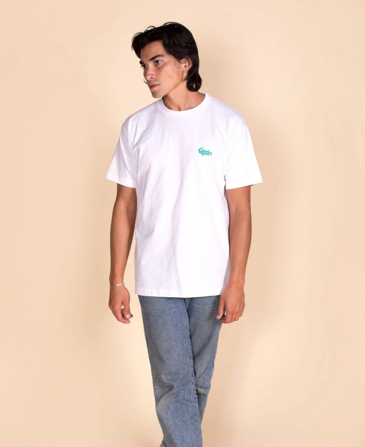 Person wearing a white t-shirt with a logo on a beige background