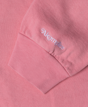 Close-up of a pink sweatshirt with 'Akgm' branding on the chest pocket.