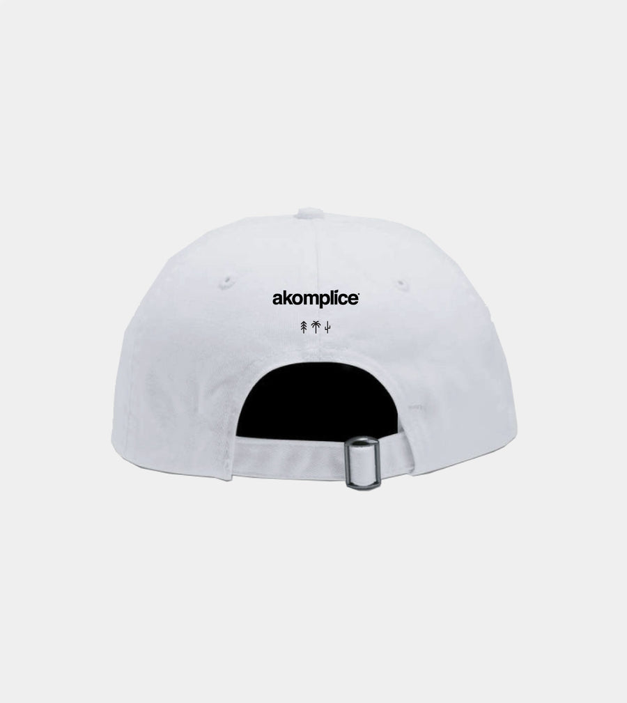 White cap with 'akomplice' logo on a light gray background