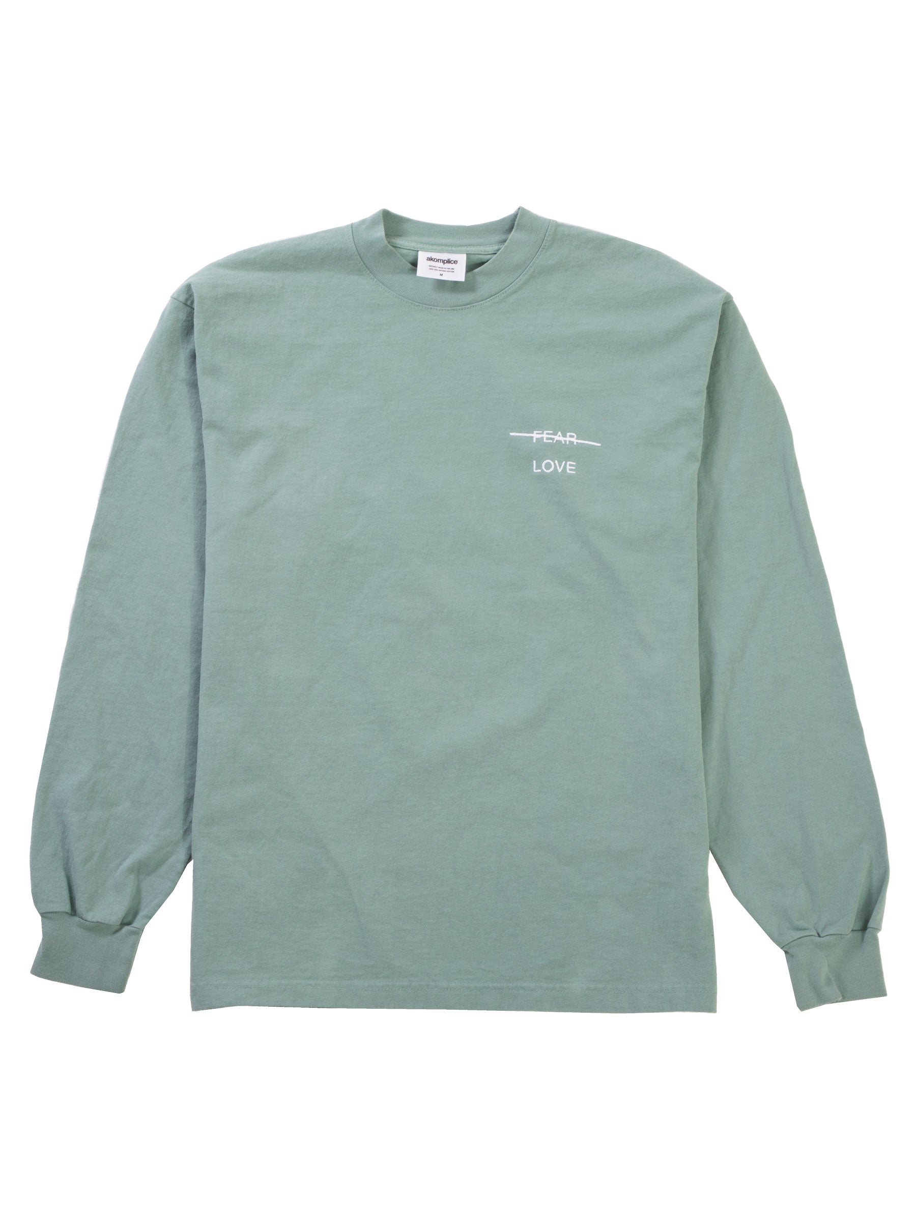 Green long-sleeve shirt with a small white logo on a white background