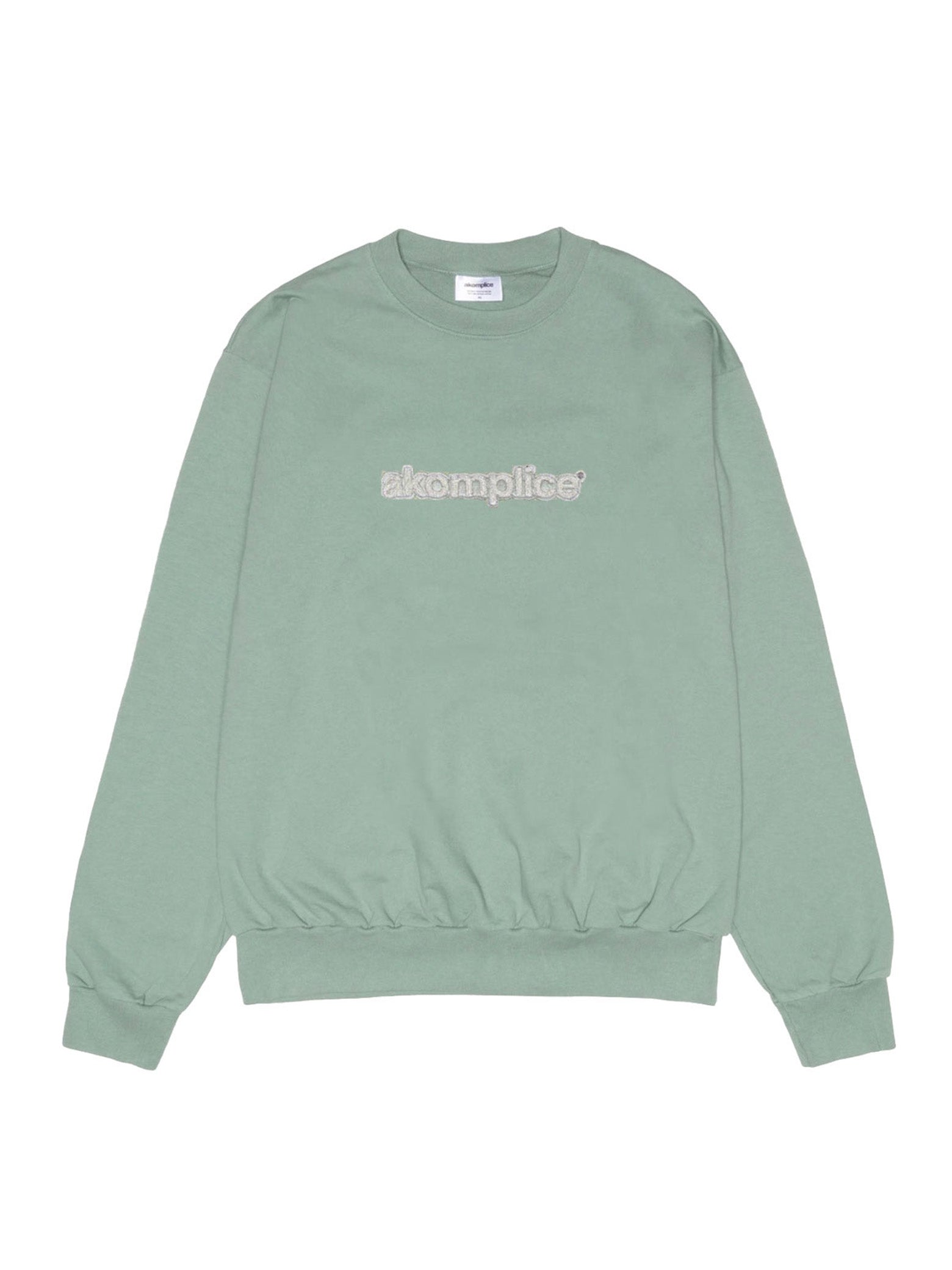 Green sweatshirt with 'skomplice' logo on a white background