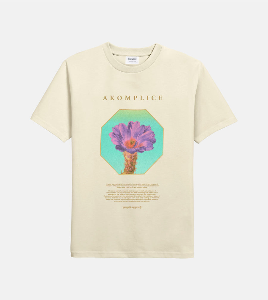 Beige t-shirt with a colorful flower graphic and 'AKOMPLICE' text on a white background