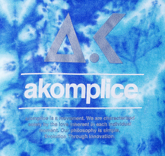 Blue tie-dye background with 'akomplice' logo and text