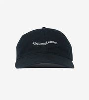 Black cap with 'Lifelong Learner' text on a light gray background