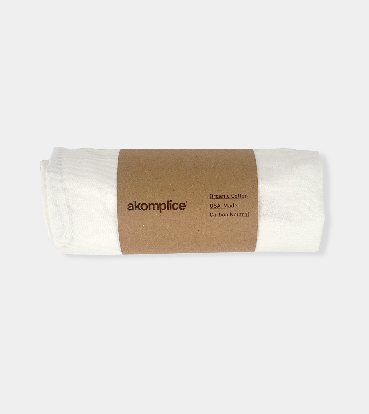 Roll of organic cotton fabric with 'akomplice' label on a white background