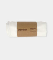 Roll of organic cotton fabric with 'akomplice' label on a white background