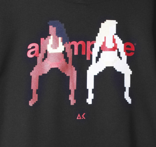 Black t-shirt with pixelated graphics of two people and the word 'alumnae' on a dark background.