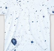 White t-shirt with blue speckles on a white background